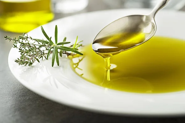 从勺子里倒出的橄榄油 — 图库照片