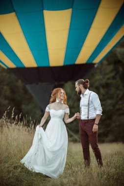 Mutlu güzel düğün çift gelin ve damat airballoon sepeti alanında yakın yürüyüş.