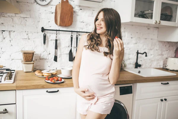 O femeie însărcinată în bucătărie ia micul dejun — Fotografie, imagine de stoc