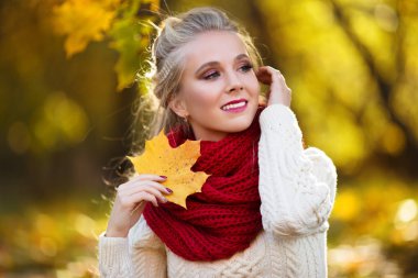 Buket sarı akçaağaç yaprakları ile güzel sarışın kız