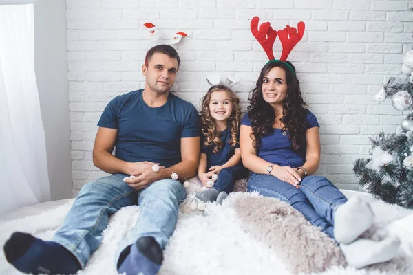 Boże Narodzenie zdjęcie rodziny. Ojciec, matka i córka są sobie rogi śmieszne Boże Narodzenie. — Zdjęcie stockowe