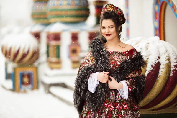 Mulher feliz bonita está vestindo roupas tradicionais russas no parque de inverno — Fotografia de Stock