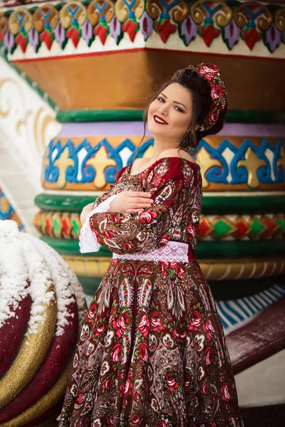 Mulher feliz bonita está vestindo roupas tradicionais russas no parque de inverno — Fotografia de Stock