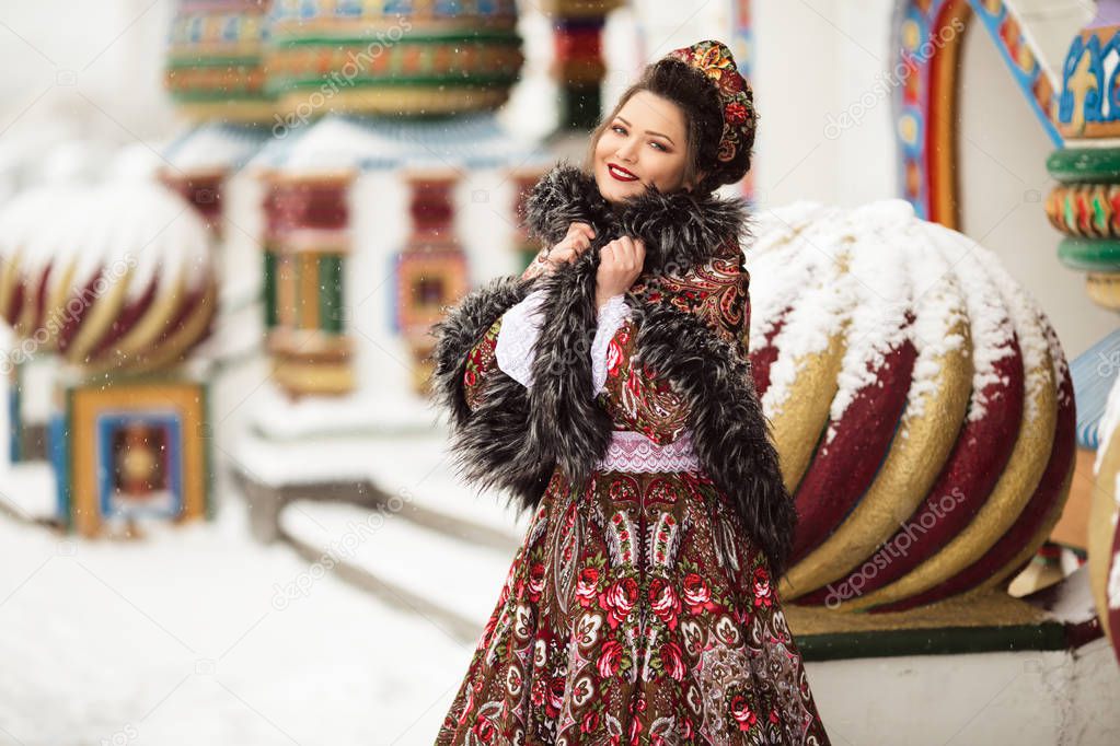 Hermosa mujer feliz está usando ropa tradicional rusa en el parque