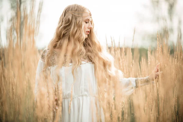 Happy smiling blonde girl is wearing white fashion dress with long blonde hair in field of ray — Stock Photo, Image