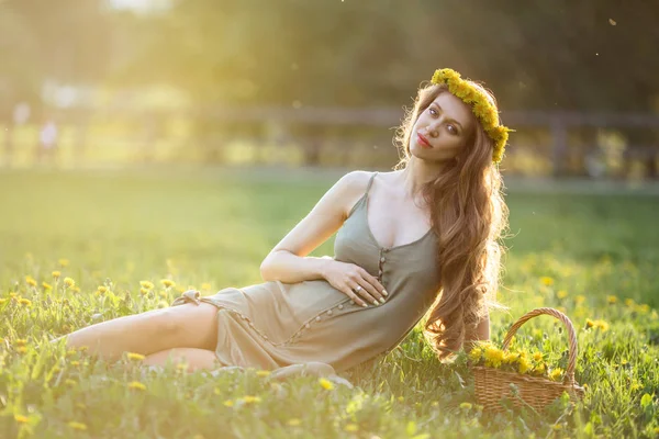 かなり妊婦は緑の芝生のある公園に座っています。 — ストック写真