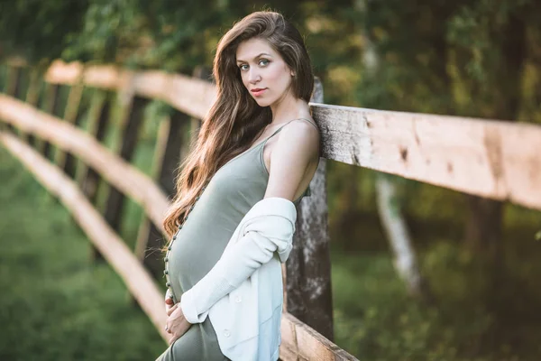 Pregnant pretty woman is posing in spring park — Stock Photo, Image