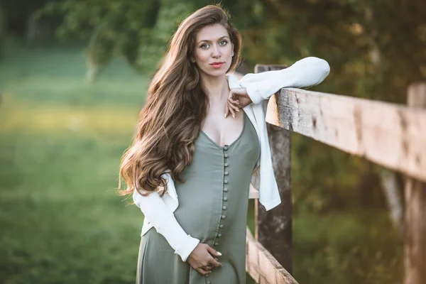 Těhotná žena hezká pózuje na jaře parku — Stock fotografie