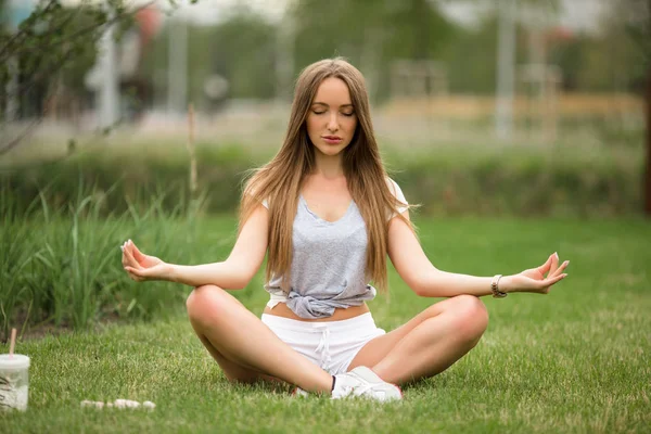 Joven chica deportiva haciendo meditación de yoga en el parque de la ciudad —  Fotos de Stock