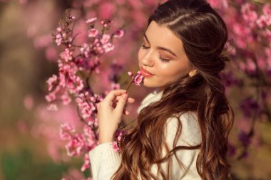 Pembe çiçekler ile çiçek ağacı yakın poz genç güzel kız portre.