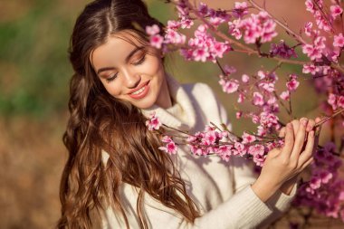 Kiraz bahçesinde çiçek ağacı yakın poz mükemmel cilt ile genç güzel kız portre