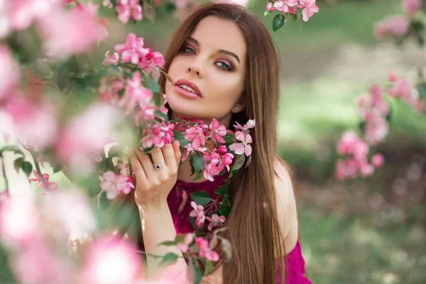 Ung vacker kvinna i blomma äpple trädgård med rosa blommor — Stockfoto