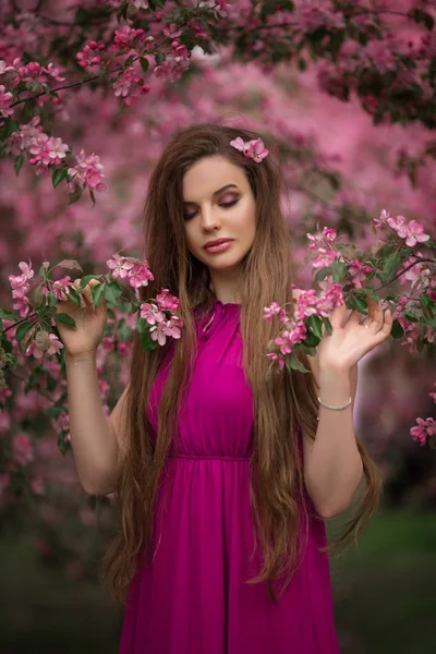 Vacker kvinna i blom äppel trädgård med rosa blommor, vårtid — Stockfoto