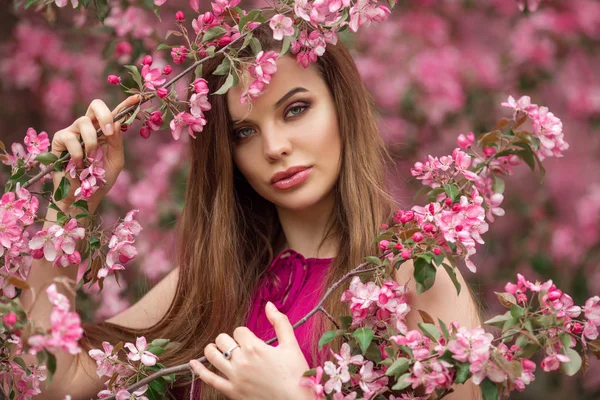 Schöne Frau im blühenden Apfelgarten mit rosa Blüten, Frühling — Stockfoto