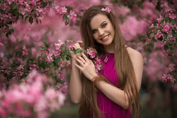 Vacker flicka i blom äppel trädgård med rosa blommor, vårtid — Stockfoto