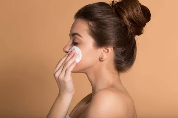 Ritratto di giovane bella donna con batuffoli di cotone che si puliscono il viso. Cura della pelle e concetto di bellezza . — Foto Stock