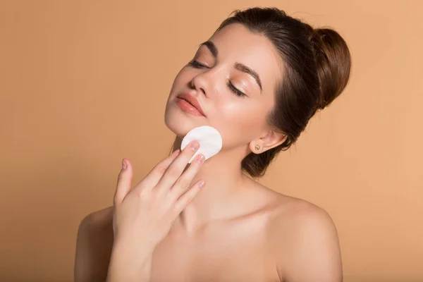 Retrato de jovem mulher bonita está limpando seu rosto de maquiagem com almofadas de algodão. Cuidados com a pele e conceito de beleza. — Fotografia de Stock