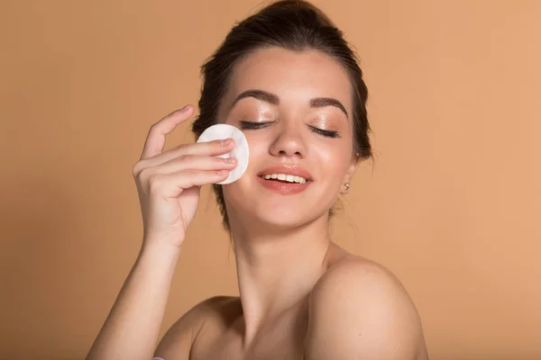 Closeup portré fiatal szép nő takarítás arcát a smink pamut párna. Bőrápolási és szépségápolási koncepció. — Stock Fotó