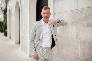 Yakışıklı işadamı beyaz moda kostümü giyiyor. Karadağ körfezi.