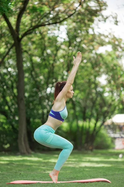 Young woman doing yoga and stretching in green park, summer time — Stock Photo, Image