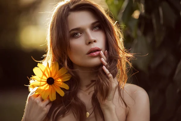Utomhus mode foto av vacker ung kvinna med gul blomma — Stockfoto