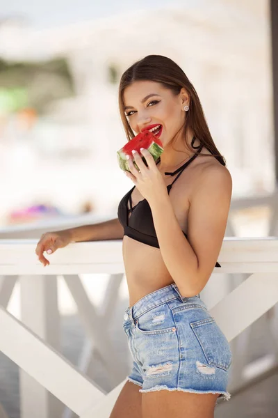 Fashion portrait of a sexy girl with watermelon on the beach — Stock Photo, Image