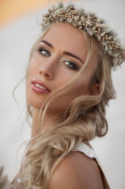 Güzel gelin portresi Dubai'de büyük çölde moda uçan elbise ve çelenk giyiyor.