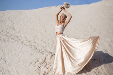 Güzel gelin Dubai'de büyük çölde moda elbise giyiyor.