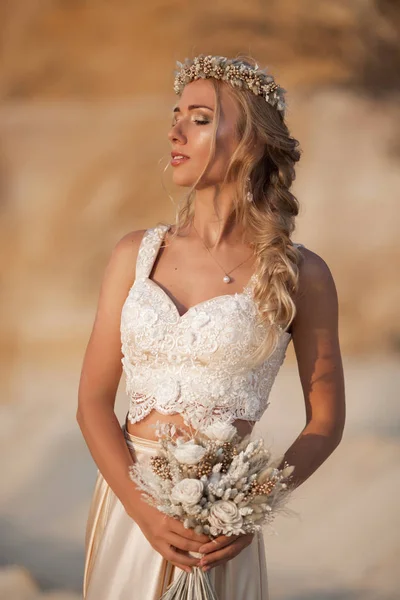 Retrato de novia hermosa está usando vestido de vuelo de moda y corona en el gran desierto de Dubai . — Foto de Stock