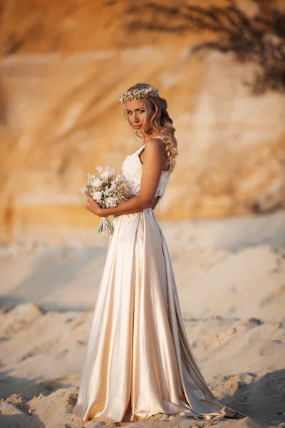 Hermosa novia está usando vestido de vuelo de moda y corona en el gran desierto de Dubai . — Foto de Stock