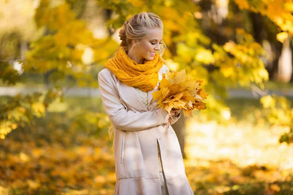 Hübsche blonde Teenie-Mädchen läuft im Herbst Park mit gelben Blättern — Stockfoto