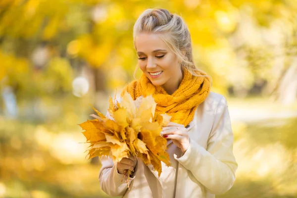 Portrait of pretty blonde teen girl with bouquet of yellow leaves — Stock Photo, Image