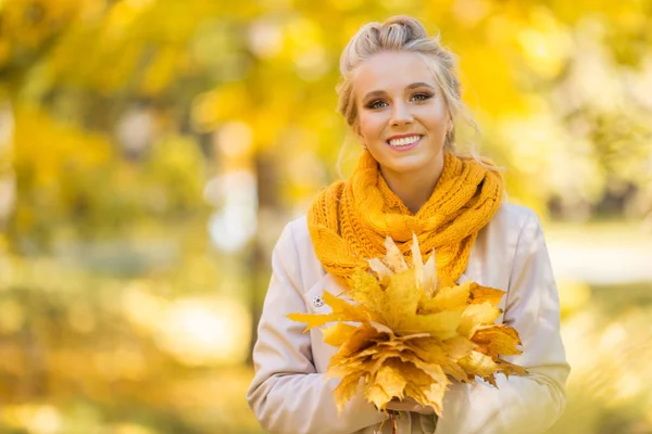 Portret van mooie blonde tiener meisje met boeket van gele bladeren — Stockfoto