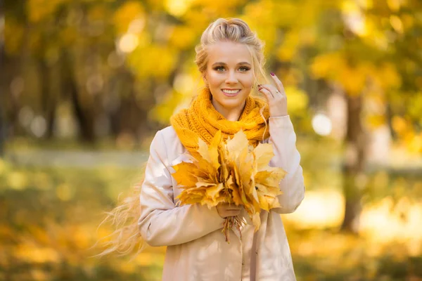 Portret van mooie blonde tiener meisje met boeket van gele bladeren — Stockfoto