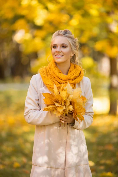 Portret van mooie blonde tiener meisje met boeket van gele bladeren — Stockfoto