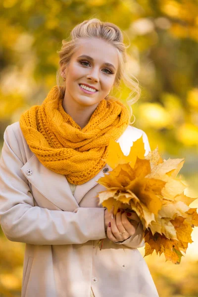 Retrato de menina adolescente loira bonita com buquê de folhas amarelas — Fotografia de Stock