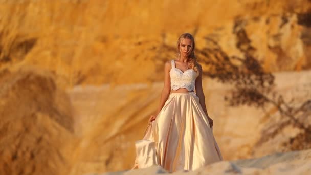 Gyönyörű menyasszony visel divat repülő ruha és koszorú a nagy sivatagban Dubai. — Stock videók