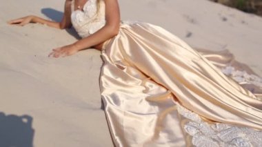 Güzel gelin Dubai'de büyük çölde moda uçan elbise ve çelenk giyiyor.