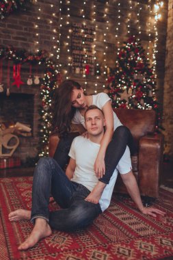 Hoş bir çift kadın ve erkek şöminenin yanında oturuyorlar. Noel zamanı.