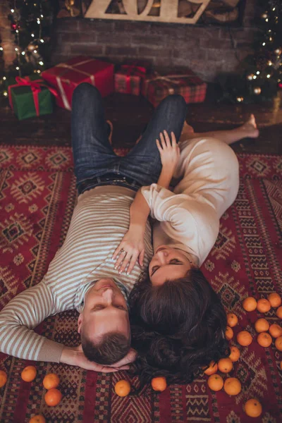 Sevimli çift kadın ve erkek evde Mandarinlerle yatıyor. Xmas zamanı.. — Stok fotoğraf