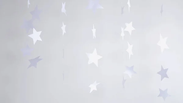 Paper stars hanging and rotating decoration on a white background. Christmas concept.