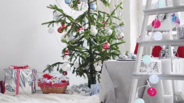 Stylish white christmas interior with decorated fir tree, stepladder, gift boxes, candles by the window. slow motion. 3840x2160 — Stock Footage Stylish white christmas interior with decorated fir tree, stepladder, gift boxes, candles by the window. slow motion. 3840x2160 Royalty Free Stock Video