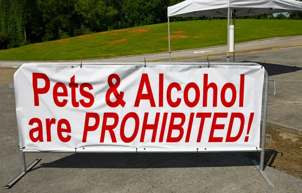日に使用されている会場の入り口に禁止されている大きな白い看板ペットとアルコールを示す赤のレタリングとお祝い — ストック写真