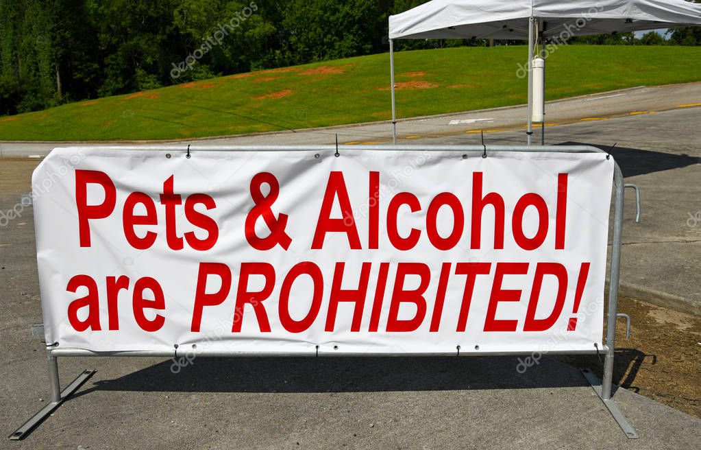 A Large White Sign with Red Lettering stating Pets and Alcohol are Prohibited at the entrance of a Venue being used for July 4th  Celebration 