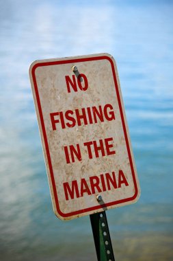 Eğilerek eski bir Marina işareti bir gölde hiç balık Metal