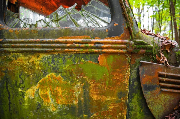 坐在垃圾场里的一辆旧的锈迹斑斑的卡车侧面的特写图片 — 图库照片