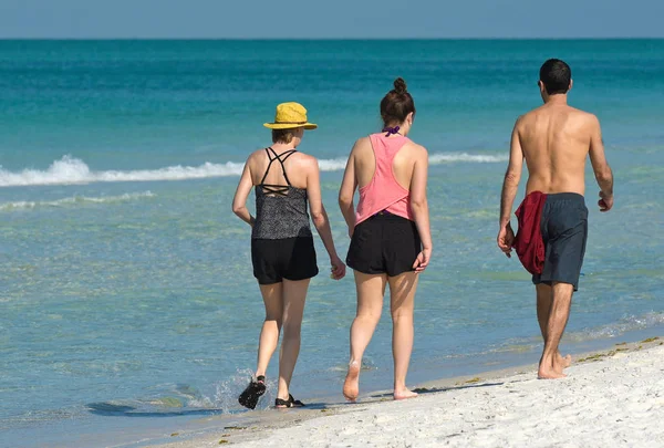 Menschen gehen am Strand spazieren — Stockfoto