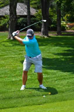 Golf oynayan genç adam.