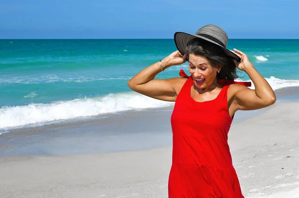 Kırmızı Yaz Elbiseli Güzel Kadın Şapkasını Tutan Güzel Yaz Günü — Stok fotoğraf