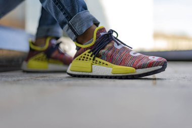 Milan, İtalya - 4 Temmuz 2020: Pharrell Williams İnsan Irkı Vücut ve Dünya NMD 'si giyen çocuk Adidas tarafından sokakta - illüstrasyon editörü